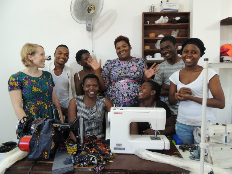 Betty with her talented team of tailors and Kitenge Store Founder Sian standing inside her newly built workshop in Tanzania laughing together