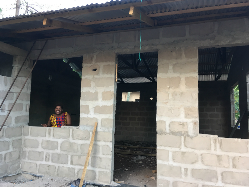 Kitenge tailor called Betty standing inside her newly built worksop in Tanzania before the windows and front door is put in