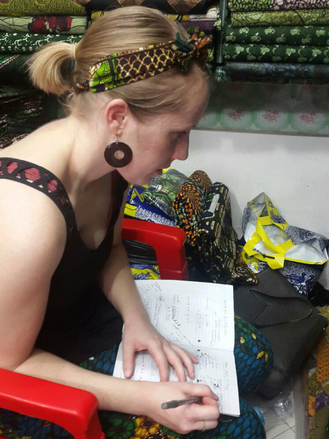 Kitenge founder Sian carefully calculating African print fabric consumption to make modern afrocentric clothing at the market in Tanzania East Africa