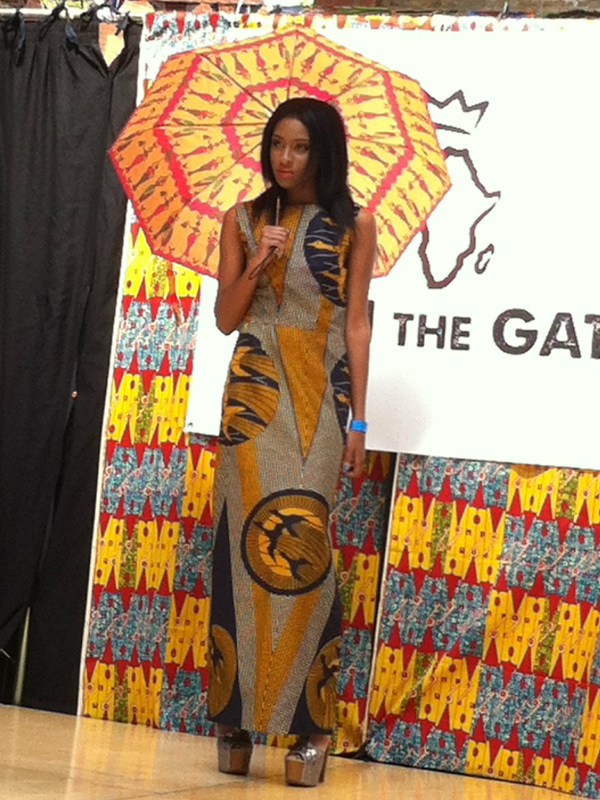Model wearing an African print maxi dress on the catwalk at Old Spitalfields Market in London, UK