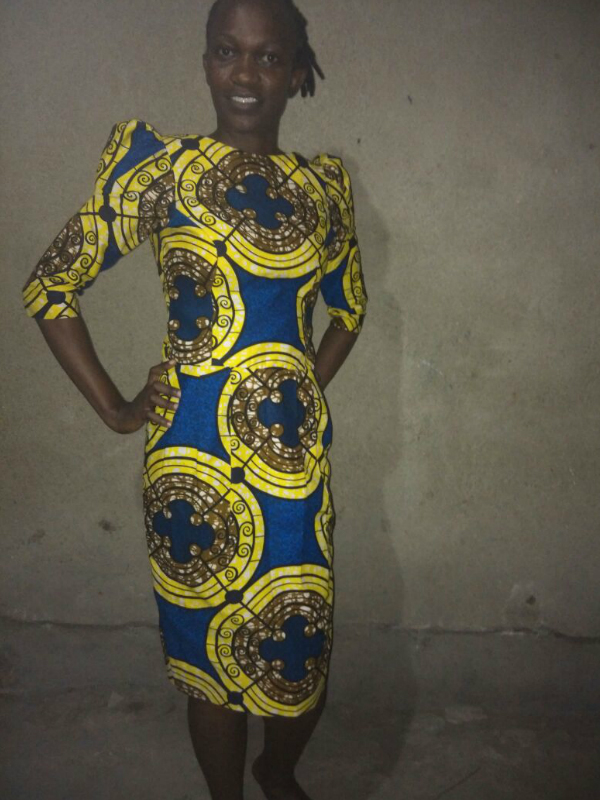 A bespoke tailor made African print pencil dress with shoulder pads worn by a women in Tanzania