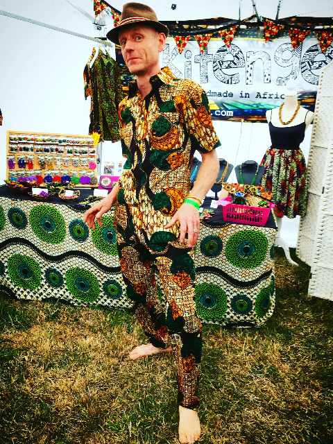 kitenge customer wearing a matching African print shirt and African print trousers at Beautiful Days Festival in Devon UK