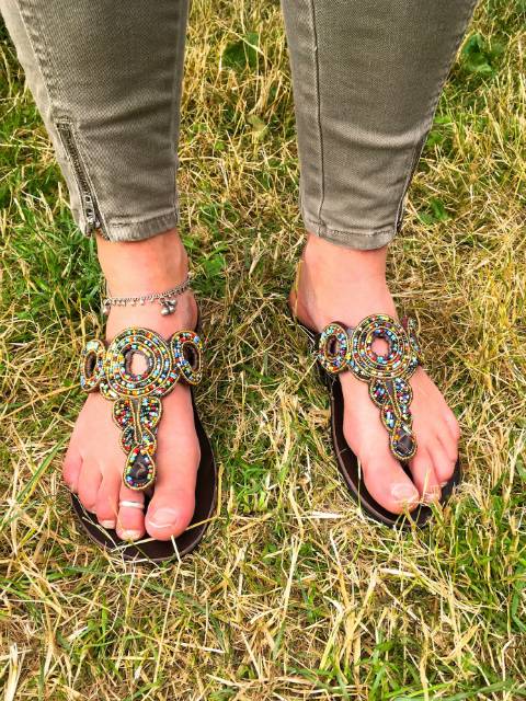 A Kitenge customer modelling her brand new African beaded leather sandals handmade in Tanzania inside our stall at LarmerTree Festival