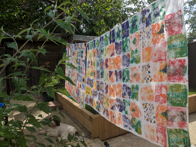 Finished children's African print inspired artwork hanging outside to dry on washing line in garden