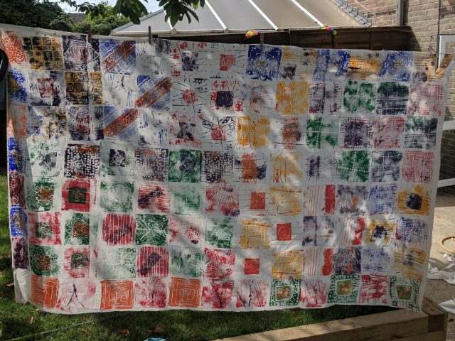primary school childrens artwork african wax print inspired artwork drying outside