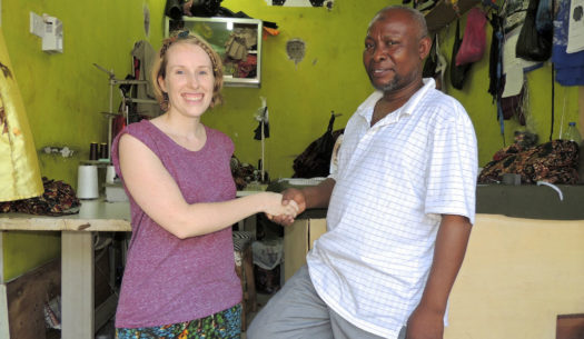 Sian shaking hands with Kitenge's main tailor Abdallah at his new workshop in Tanzania