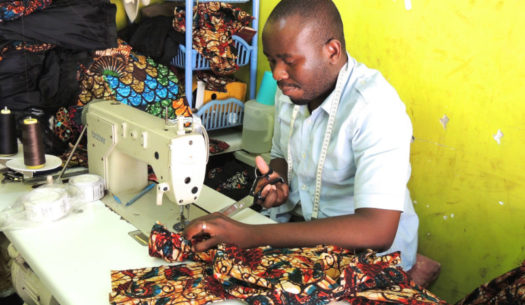 Kitenge's newest tailor called Hassan making a men's shirt in the workshop in Tanzania