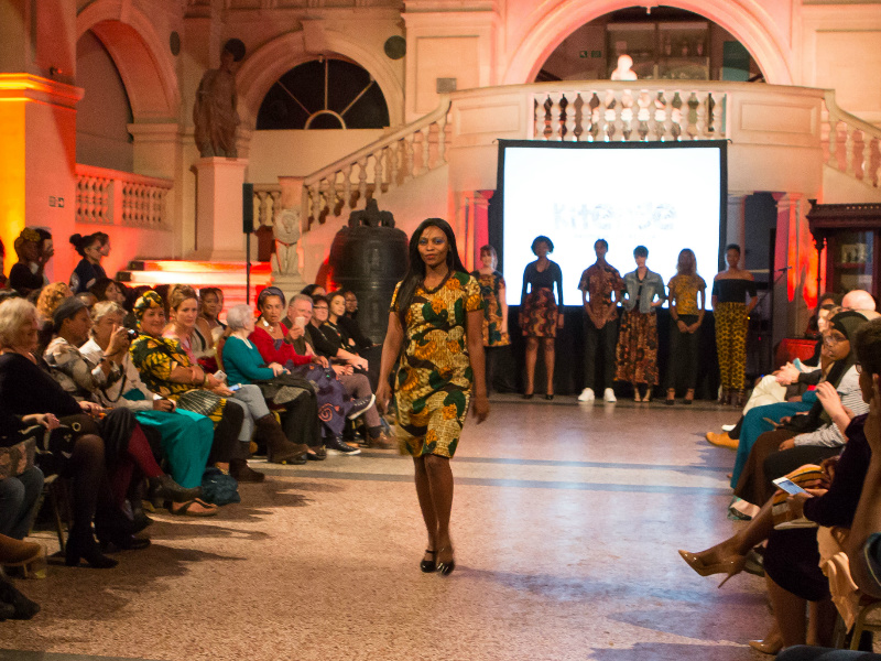 Women's gold African print pencil dress worn by a South African model at the Fabric Africa Fashion Show by Bristol Museum