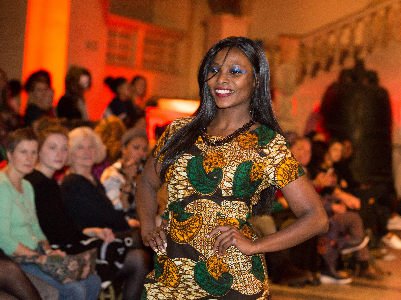 Women's gold African print pencil dress model wearing close up image on the Fabric Africa catwalk at Bristol Museum