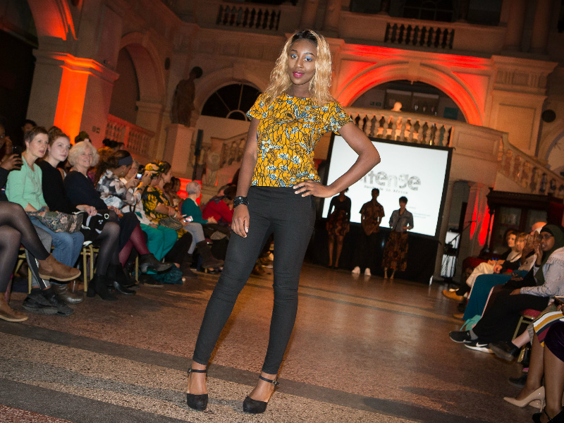 Women's yellow floral African print top worn by a model on the catwalk at the Fabric Africa fashion show at Bristol Museum