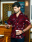 Men's maroon flower custom-made African print short sleeve shirt model wearing front view holding phone