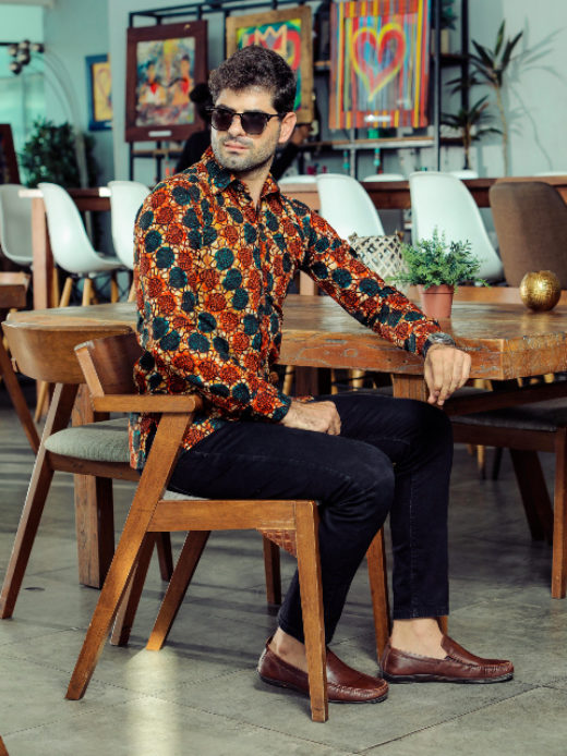 Men's red/blue shells custom-made African print long sleeve shirt model wearing sat down side view full outfit