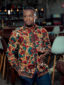 Men's red floral custom made African print long sleeve shirt model wearing front view hand in pocket