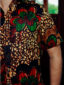 Men's red/green flower custom-made African print short sleeve shirt model wearing pocket closeup