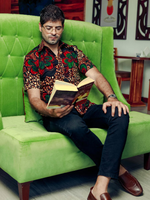 Men's red/green flower custom-made African print short sleeve shirt model wearing sitting down reading book full outfit