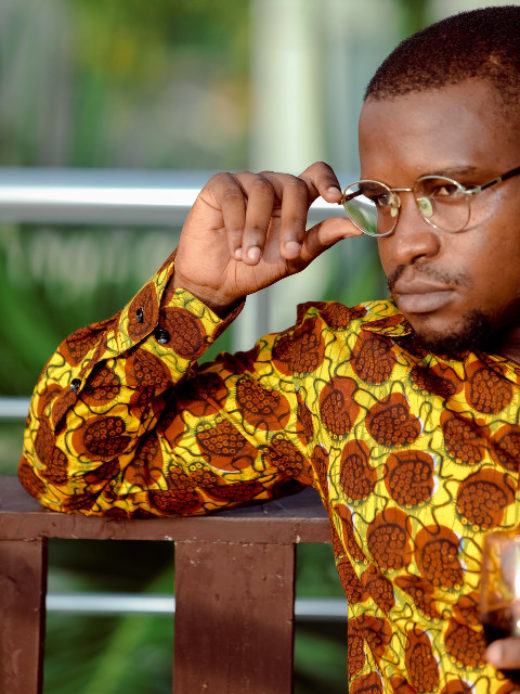 Men's yellow/brown shells African print long sleeve shirt model wearing cuff closeup