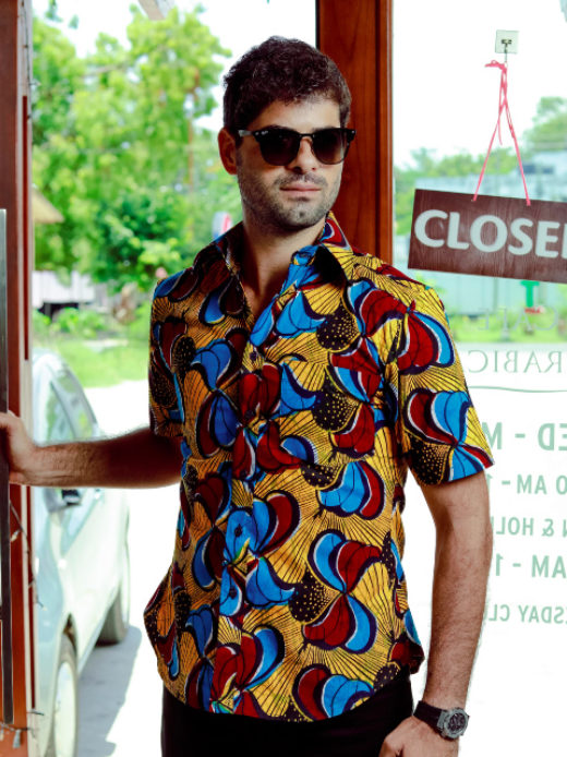Men's yellow/red/blue peacock custom-made African print short sleeve shirt model wearing front view closeup