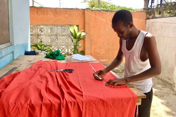 Kitenge Store African menswear tailor creating the pattern to make a custom made shirt in Tanzania