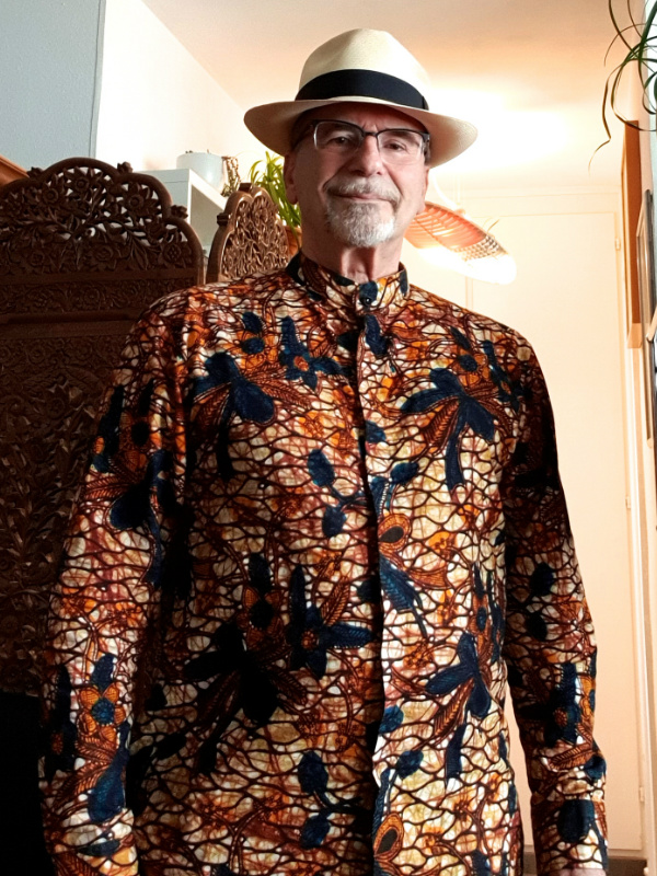 Kitenge Store customer from Switzerland modelling his gold floral African print made to measure shirt with long sleeves mandarin collar and covered placket hidden buttons at home