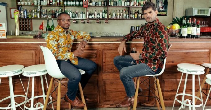 Men's custom-made African print shirts models sat at bar