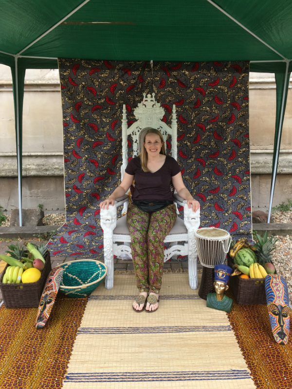 Kitenge Founder Sian in the African themed photo booth wearing purple African print trousers at AfroFest Bristol 2019