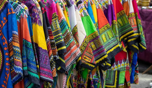 Brightly coloured traditional African clothing dashiki t-shirts hanging on clothing rail