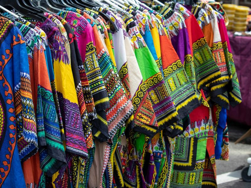 Brightly coloured traditional African clothing dashiki t-shirts hanging on clothing rail