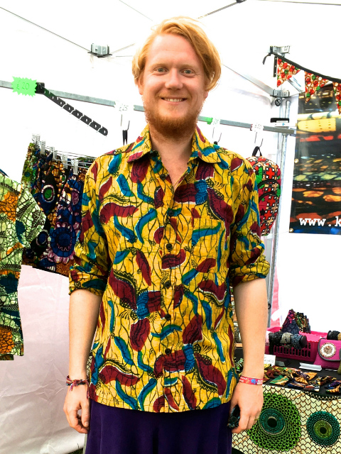 Customer wearing kitenge African print shirt with long sleeves rolled up at Womad festival