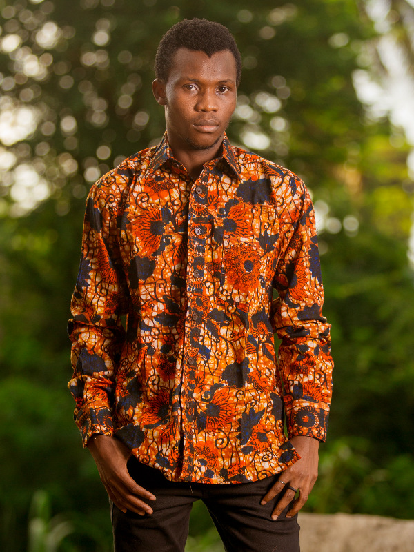 Men's red floral African print shirt with long sleeves model wearing outside in Tanzania