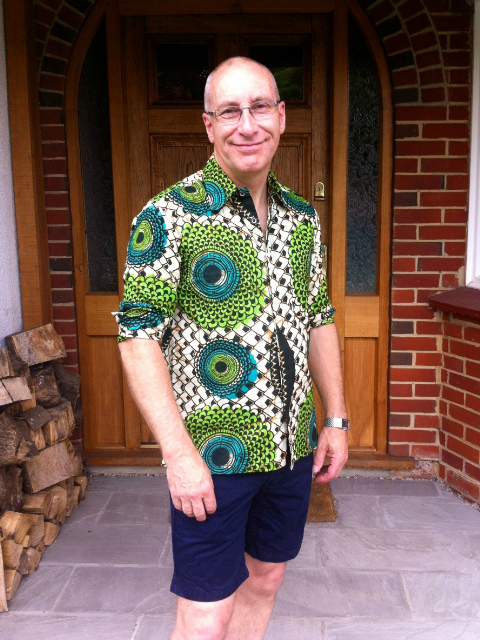 A happy Kitenge customer wearing his African menswear shirt at home outside in the garden