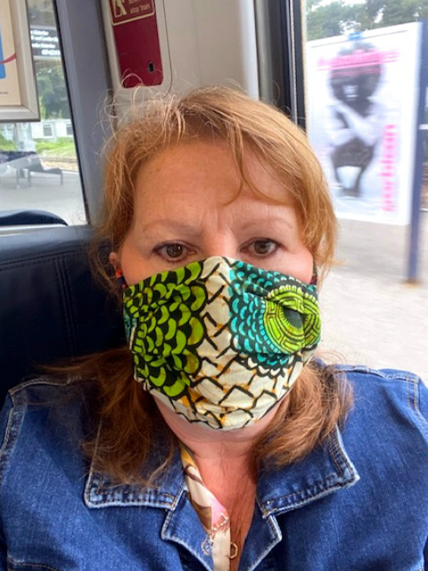 A Kitenge customer wearing her African print fabric face mask on the train in UK