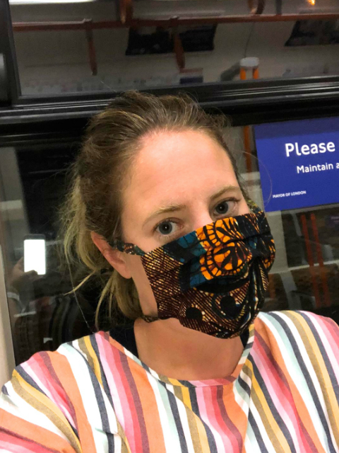 A Kitenge customer wearing her ankara fabric face mask on The Tube in London
