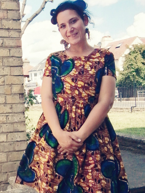 Kitenge customer modelling her yellow African print dress outside in London UK