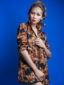 Model wearing women's red/blue floral made to measure shirt by Kitenge sleeves rolled up
