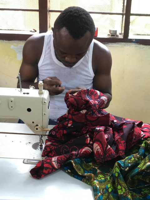 Kitenge tailor making a custom made shirt using original African print fabric