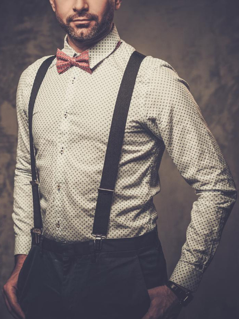 Model wearing suspenders with shirt and bow tie