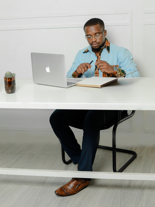 Men's custom-made plain light blue long sleeve shirt with optional African wax print fabric contrasts model wearing sat down in office full outfit