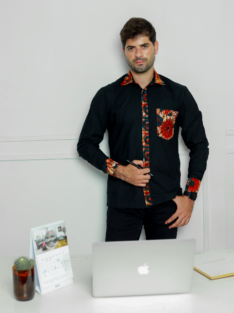 Men's plain black custom-made long sleeve shirt with optional African print fabric contrasts model wearing front view stood in front of work desk