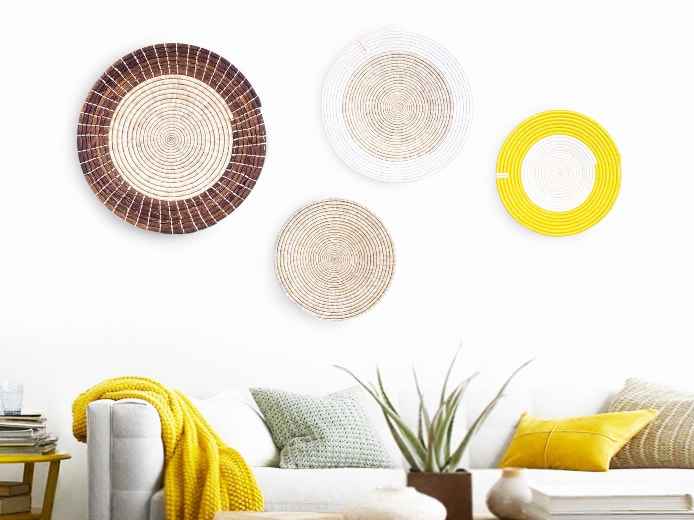 Handwoven table mats by Womencraft displayed on wall above sofa African style interior ideas