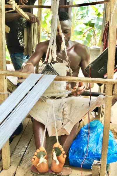 Kente weaver Ghana controlling handloom using feet