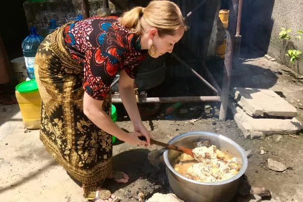 Kitenge Store founder Sian cooking Christmas dinner on open fire Tanzania wearing African print shirt and ankara fabric