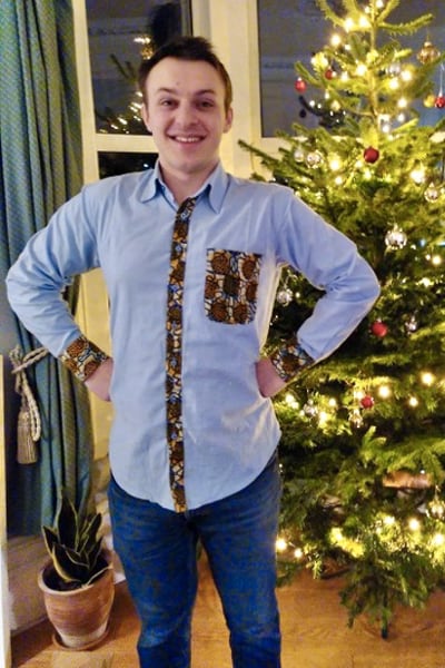 Kitenge customer wearing men's light blue made to measure shirt with African print fabric contrasts UK