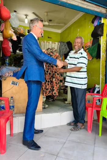 Kitenge Store master tailor Abdallah shakes hands with British High Commissioner to Tanzania